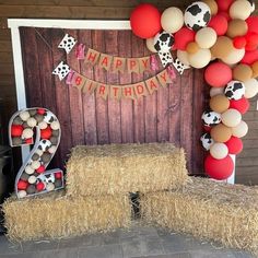 a birthday party with hay bales, balloons and farm animals on the front wall