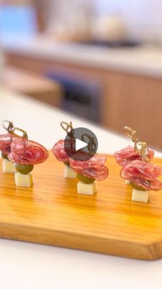 four tiny figurines are sitting on a wooden board