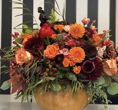 a vase filled with lots of flowers on top of a table