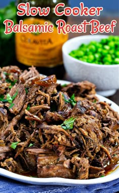 slow cooker balsamic roast beef on a white plate with green peas in the background