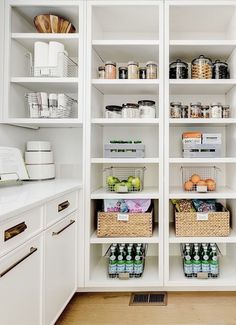 an organized pantry with white shelving and lots of food