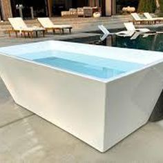 a large white rectangular tub sitting next to a swimming pool