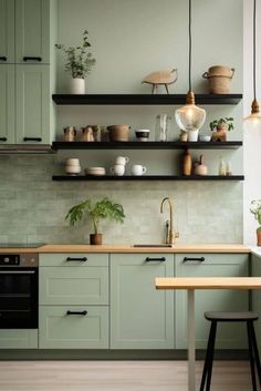 a kitchen with green cabinets and shelves filled with pots, pans, and plants