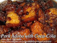 pork adob with coca cola in a white bowl on top of a wooden table