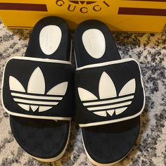 New With Box White Flat Gucci Slides, Designer White Sandals With Rubber Sole, Black Designer Sandals With Logo, Luxury Black Slides With Rubber Sole, Luxury White Gucci Sandals, White Gucci Sandals With Branded Insole, Gucci Black Luxury Sandals, Luxury Gucci Slides With Rubber Sole, Black Gucci Luxury Sandals