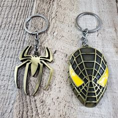 two spider - man key chains are sitting next to each other