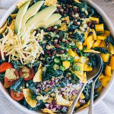 a salad with beans, avocado, tomatoes and other vegetables in a bowl