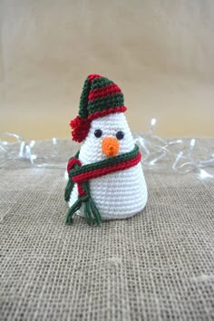 a small crocheted snowman with a scarf and hat on it's head