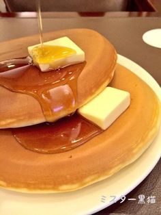 pancakes with syrup and butter on top are sitting on a plate, ready to be eaten