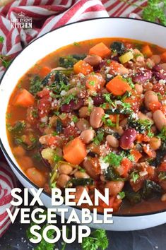 a white bowl filled with bean and vegetable soup on top of a red and white towel