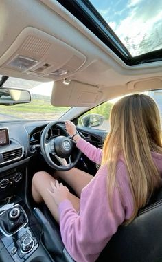 a woman sitting in the driver's seat of a car