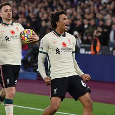 two soccer players are on the field and one is holding a ball in his hand