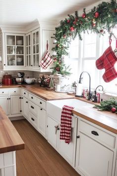 a kitchen decorated for christmas with stockings hanging from the ceiling and decorations on the counter