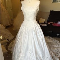 a white wedding dress on display in a room