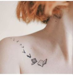 a woman with a book tattoo on her back shoulder and an open book flying in the air