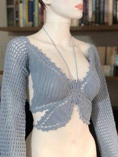 a mannequin wearing a blue sweater with lacy crochet on it's shoulders