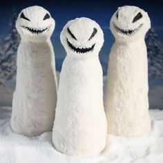 three white stuffed animals sitting in the snow