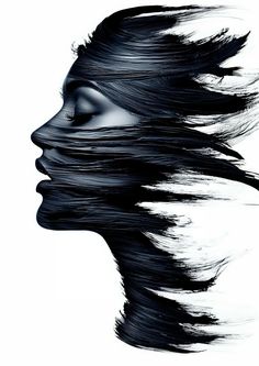 a woman's face with black hair blowing in the wind