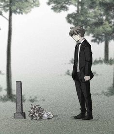 a man in a suit standing next to a grave and looking at the ground with flowers on it