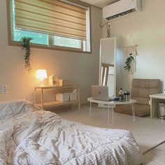 a bed room with a neatly made bed next to a desk and chair in front of a window