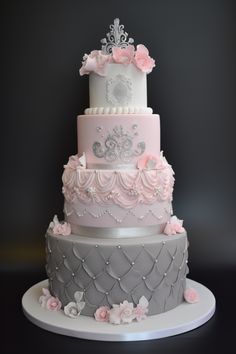 a three tiered cake with pink and gray decorations