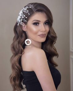 a woman with long hair wearing a black dress and a white flower headpiece on her head