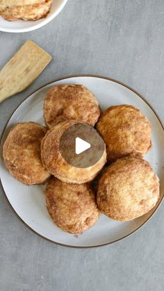 a white plate topped with donuts next to a bowl of doughnuts