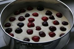 a pot filled with pudding and cherries on top of a stove