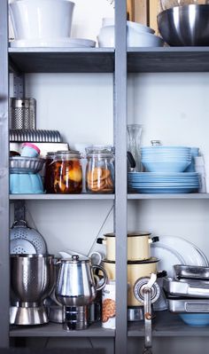 the shelves are filled with dishes and pans