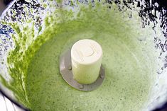 a blender filled with green liquid on top of a counter