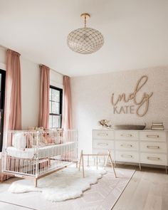 a baby's room with white furniture and pink curtains