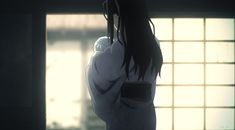 an anime character standing in front of a window