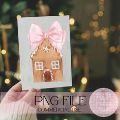 a person holding up a card with a gingerbread house on it and a pink bow