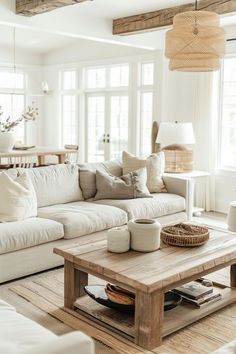 a living room filled with white furniture and lots of natural light coming through the windows