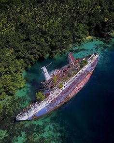 an aerial view of a large ship in the middle of some water surrounded by trees