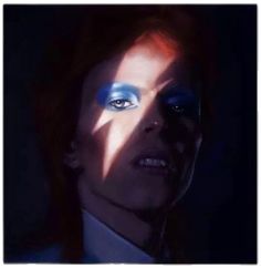 a woman with blue eyes and bright make - up on her face, in the dark