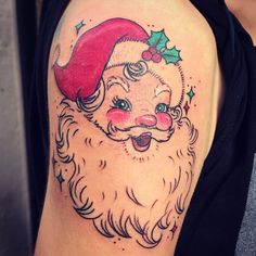 a close up of a person's arm with a tattoo on it and a santa hat