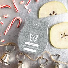 an apple slice next to some candy canes and apples on a table with other items