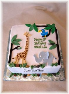 a birthday cake with an elephant, giraffe and bird on it's side