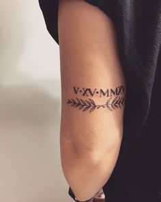 a woman's arm with an arrow tattoo on the left side of her arm