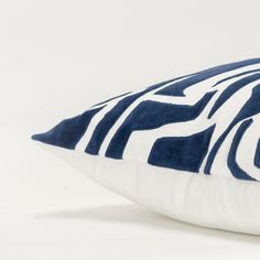 a blue and white pillow on a white background