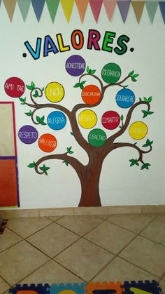 a child's room with a tree painted on the wall and colorful rugs