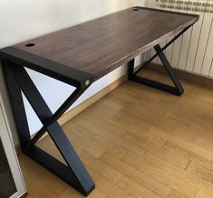 a wooden table sitting on top of a hard wood floor next to a radiator