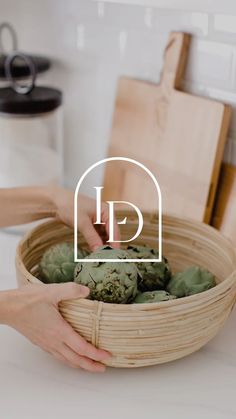 a person holding a bamboo basket filled with succulents on top of a counter