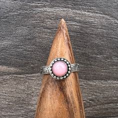 Sweet little Pink Opal and sterling silver ring, Size 5. Pink Opal is a common opal, primarily found in Australia.   This little beauty is is set in sterling silver, designed and created by me in my Arizona studio.   The stone is 7 mm with the setting being 10mm across. It is accented with a small bead wire around the bezel and soldered to a finely detailed floral band. I do have more of these stones, so if you want this ring in a different size, let me know!  I can make one for you, no extra ch Pink Granite And Opal Ring, Adjustable Pink Opal Ring As A Gift, Silver Opal Stackable Rings As Gift, Pink Sterling Silver Opal Ring For Anniversary, Pink Opal Ring In Sterling Silver For Anniversary, Adjustable Nickel-free Silver Opal Ring, Pink Sterling Silver Moonstone Promise Ring, Pink Opal Rings As A Gift, Adjustable Round Opal Ring With Stone Setting