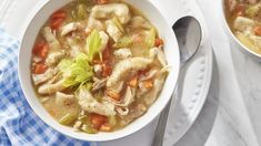 two bowls of chicken noodle soup on a white and blue checkered table cloth