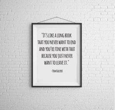 a white brick wall with a black frame hanging on it's side and a quote above