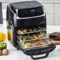 an air fryer with food in it sitting on a counter next to other foods