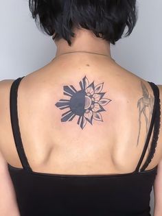 a woman with a sun tattoo on her back