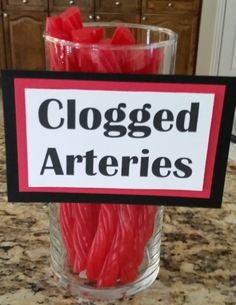 a close up of a glass on a table with candles in it and a sign that says clogged articles